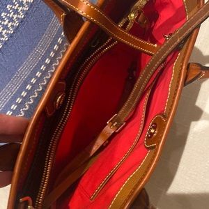 Dooney amd Bourke small bucket back with cross body strap. Brownish tan